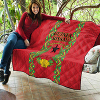 Red quilted throw blanket with Guinea-Bissau crest, black star, and green border