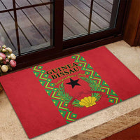 Red rubber doormat with Guinea-Bissau Independence Day emblem, laurels, and shell
