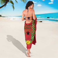 Red Guinea-Bissau sarong wrap with green panel, black star, and shell emblem