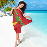 Red sarong with green geometric design, black star, and yellow shell motifs