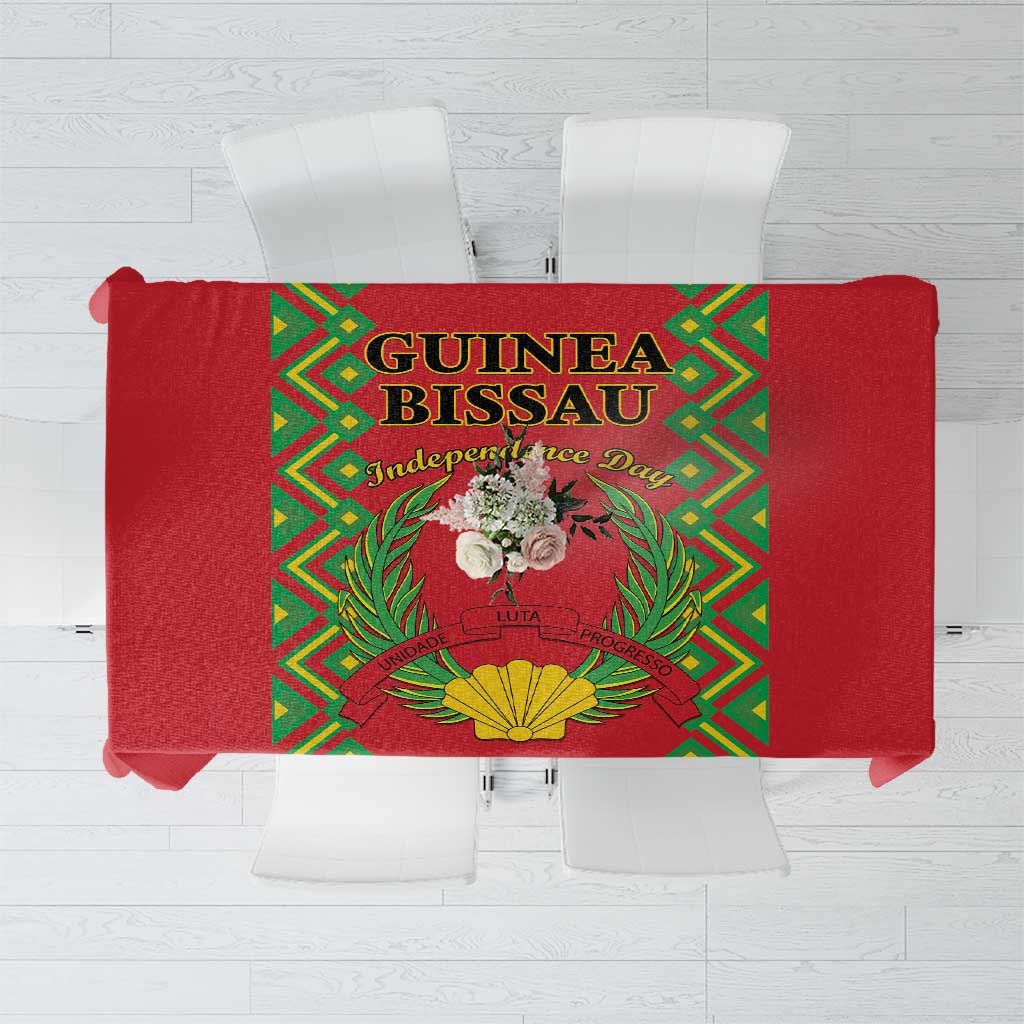 Red tablecloth with green geometric border and Guinea-Bissau independence emblem center