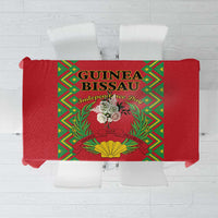 Red tablecloth with green geometric border and Guinea-Bissau independence emblem center