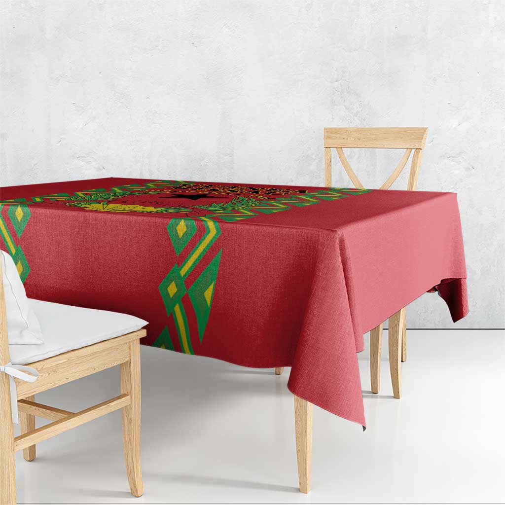 Red tablecloth with green diamond trim along the edge, draped over a dining table