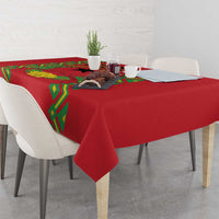 Red tablecloth with green geometric pattern corners, laid across a dining table