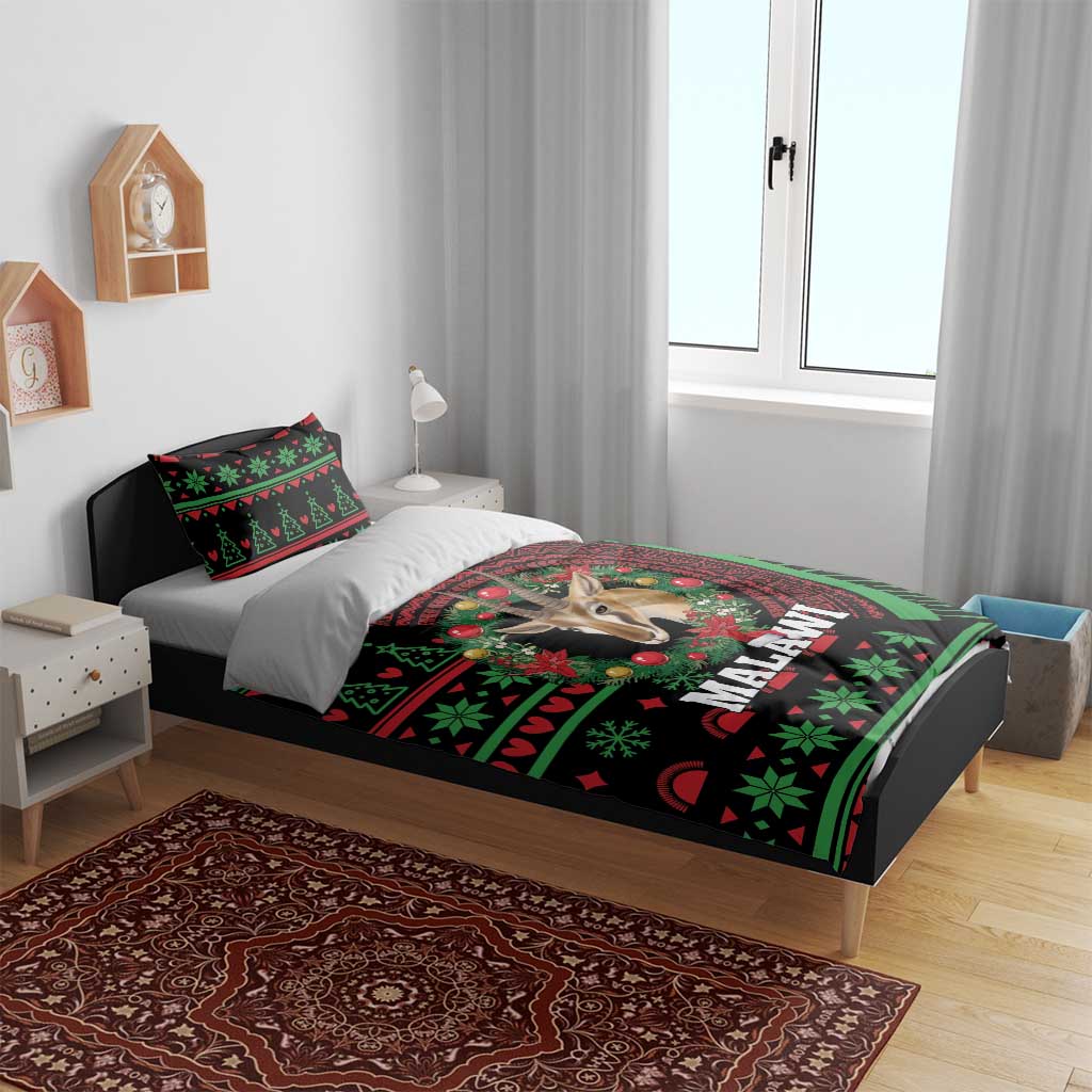 Black Malawi Christmas bedding set on bed with antelope design and green/red holiday motifs