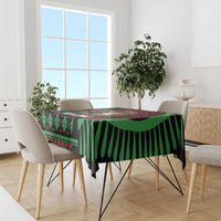 Christmas tablecloth with black base, green stripes, and red geometric accents on table