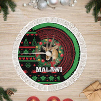 Round Christmas tree skirt with white fringe edge and Malawi deer artwork in green/red