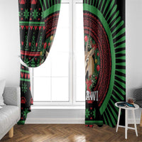 Black window curtain close-up with green/red African festive pattern, deer face and sunburst
