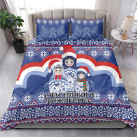 Blue Christmas bedding set on bed with matryoshka Santa doll artwork and decorative text