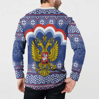 Blue back button sweatshirt on model, showing coat of arms graphic over festive pattern