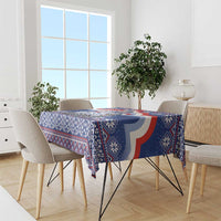 Blue Christmas tablecloth with festive geometric motifs on dining table and chairs.
