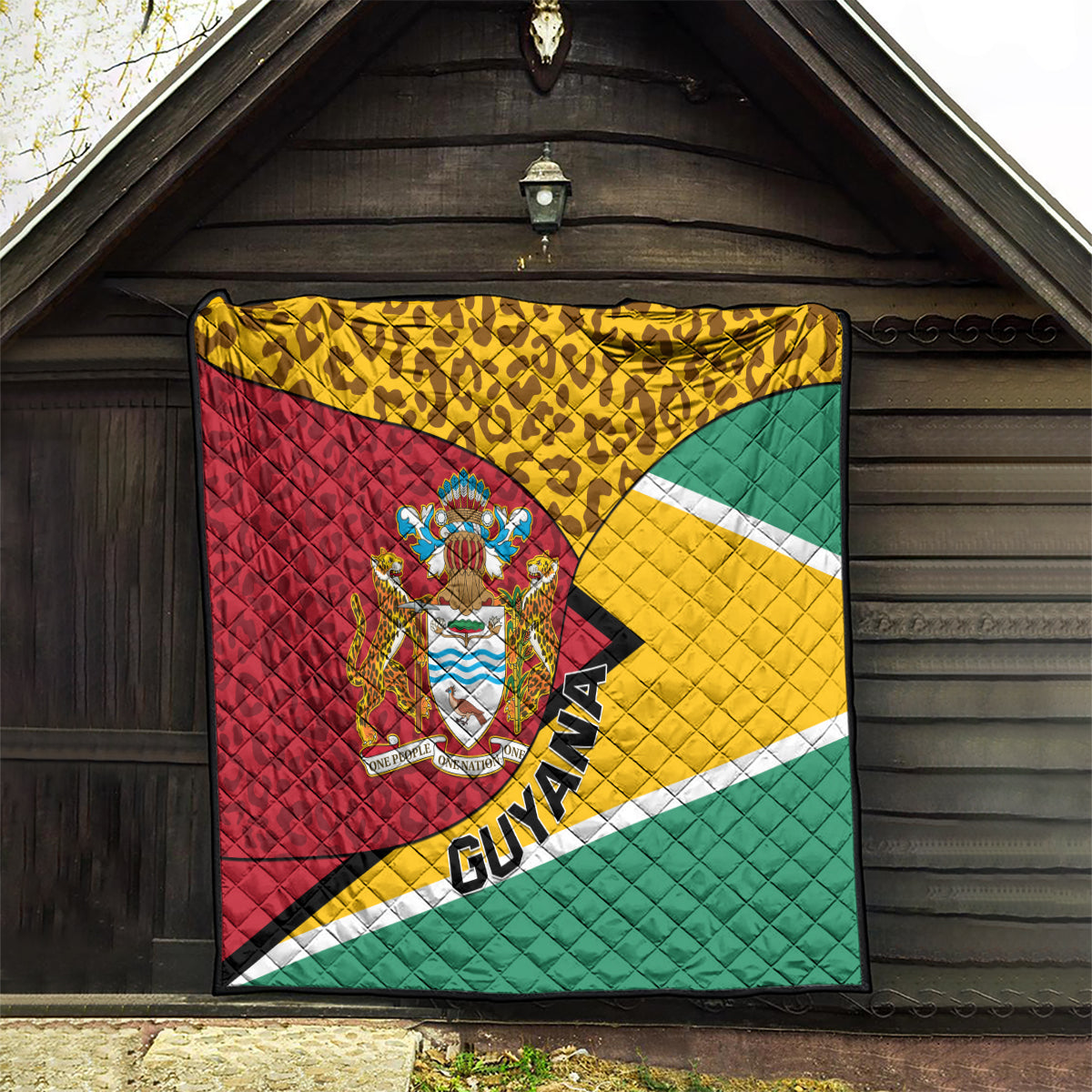 Guyana quilt blanket with crest emblem, leopard pattern trim, and tricolor flag stripes