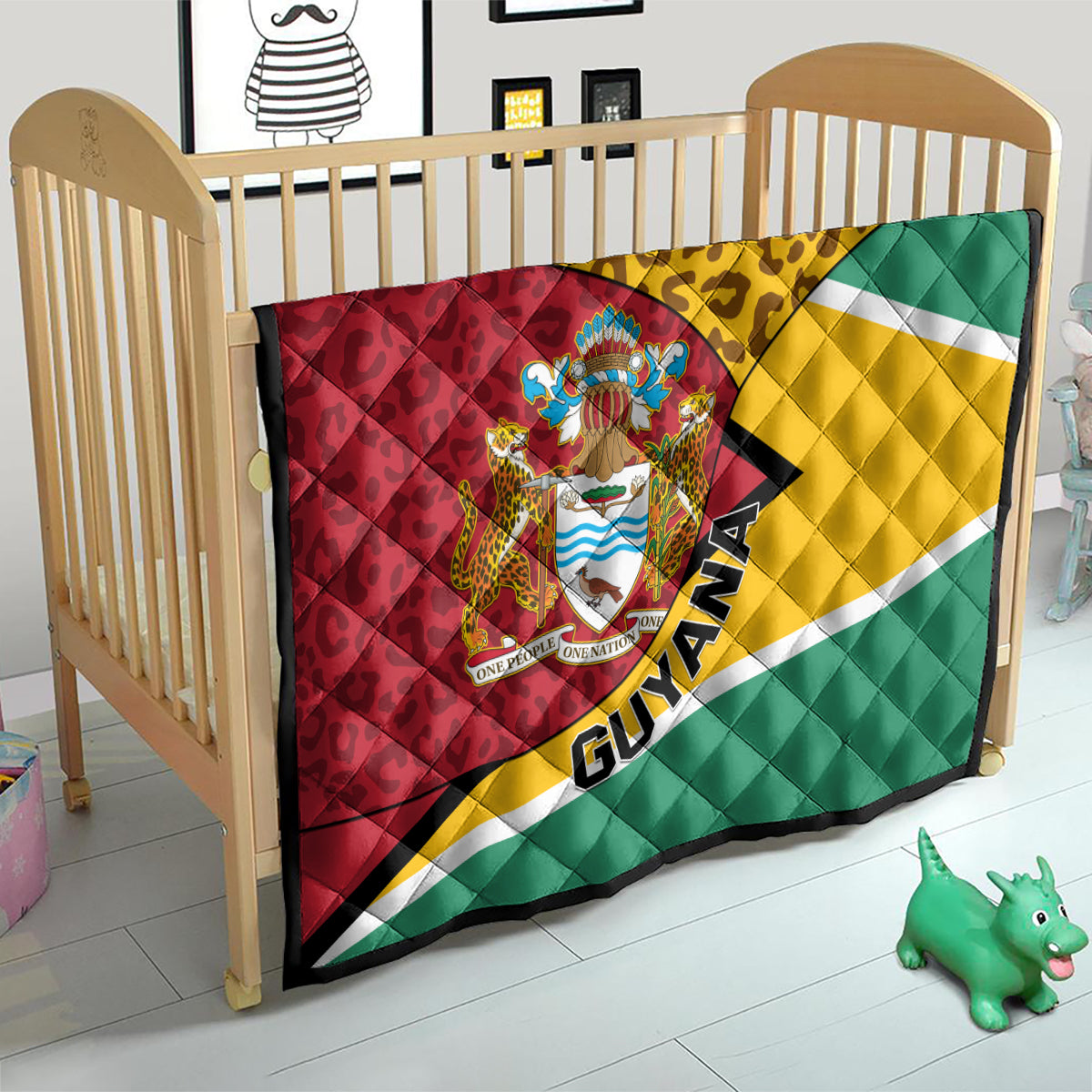 Guyana quilt blanket on crib with crest emblem, leopard band, and tricolor flag stripes