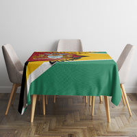 Guyana Republic Day tablecloth on dining table, green field with yellow/teal stripe border.