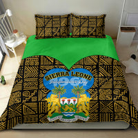 Bedding set on bed with green solid top and black-gold patterned cover, Sierra Leone Independence Day design