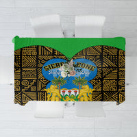 Green-trimmed tablecloth with black and gold African geometric pattern and crest center