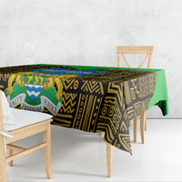 Black, gold, and green tablecloth with African graphic pattern draped over dining table