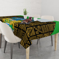 African patterned tablecloth in black and gold with green edge laid across dining table