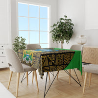 Dining tablecloth with black, gold, and green African pattern, draped over tabletop
