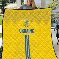 Yellow football quilt with quilted pattern and blue Ukraine text, emblem, and stripes