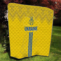 Yellow quilt with quilted diamond pattern and blue Ukraine emblem, text, and stripes