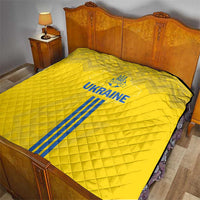 Yellow Ukraine football quilt on a bed, featuring blue emblem, text, and stripes