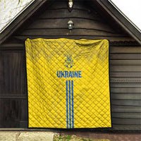 Yellow quilt with blue Ukraine emblem and vertical stripes, displayed on an entry wall