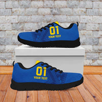Blue football sneakers with yellow logo, lace-up style, and black tread sole