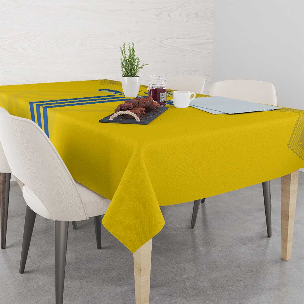 Yellow tablecloth draped on dining table with blue stripe panel and folk motif