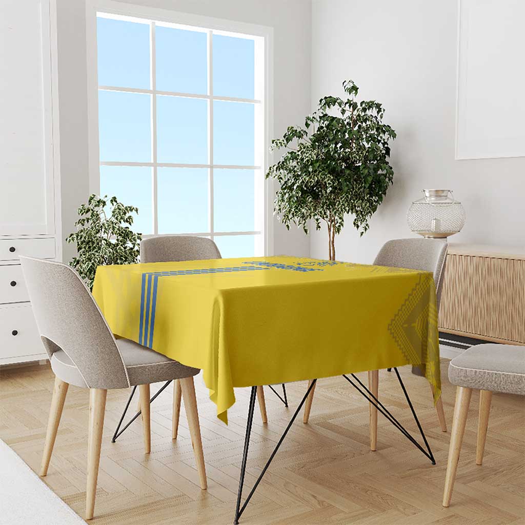 Yellow tablecloth on dining table with blue stripe edging and patterned corners