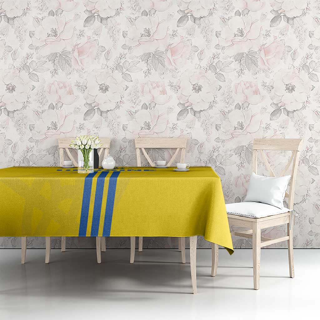 Yellow tablecloth with blue vertical stripes and subtle folk border on table