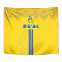 Yellow Ukraine tapestry close-up with blue 'UKRAINE' text, trident crest, and striped emblem