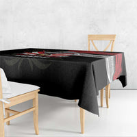 Black tablecloth draped over table with red eagle artwork and geometric border