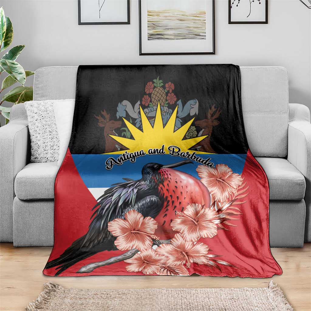 Antigua and Barbuda blanket over gray sofa, red and black with frigatebird and hibiscus blooms