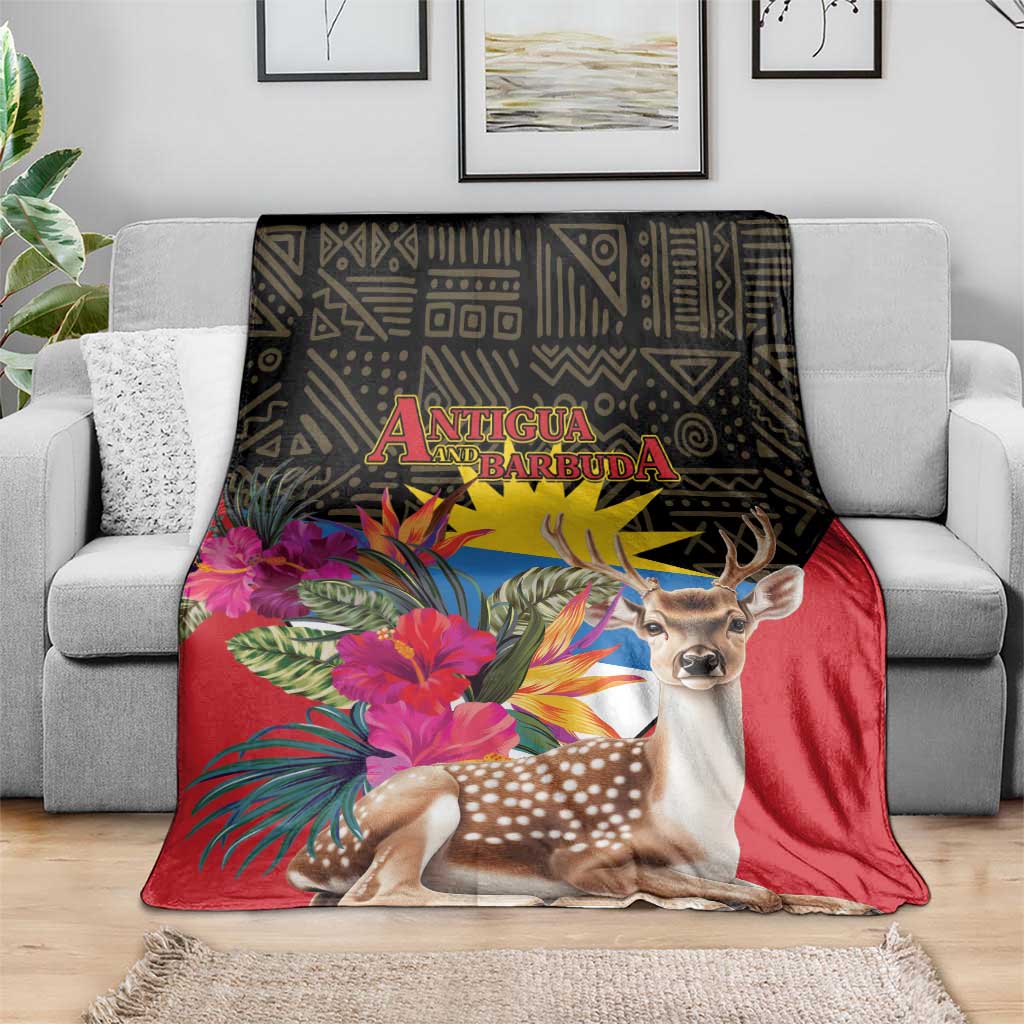 Antigua and Barbuda tropical deer print blanket on gray couch, red with deer and palm flowers