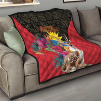 Red quilt blanket with black border, deer and tropical flowers on a sofa
