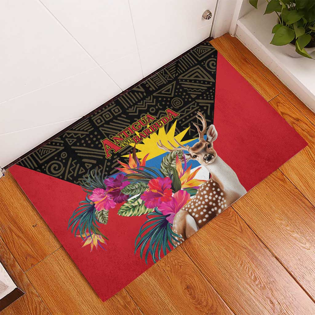Corner view red rubber doormat with black pattern, deer head, and bright tropical blooms