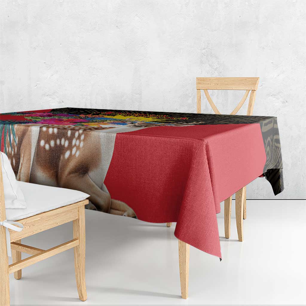 Red tablecloth with deer imagery and black patterned edge on dining table