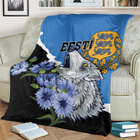 Wolf face and blue flowers on a blue-and-black Esti print blanket over a sofa