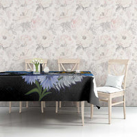Blue tablecloth with wolf head and wildflowers, styled on a dining table