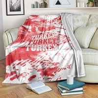 Red and white Turkey map grunge blanket with bold TURKEY text, draped over sofa.