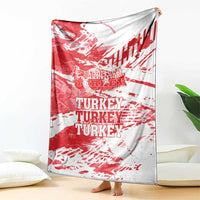 Red and white Turkey blanket with TURKEY text, hanging beside couch.