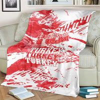 Red and white Turkey blanket with grunge-style TURKEY text, draped over armchair.