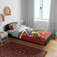 Suriname-themed bedding set on bed: green/red duvet with bird artwork and two pillows