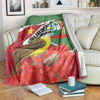 Suriname-themed blanket draped over sofa, green-and-red flag print with bird and flowers