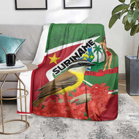 Suriname-themed blanket on sofa, green-and-red flag print with bird, palm and woman