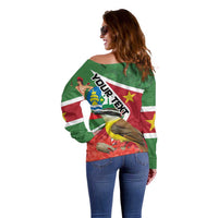 Women’s off-shoulder sweater, green with back flag graphic, bird design, and star accents