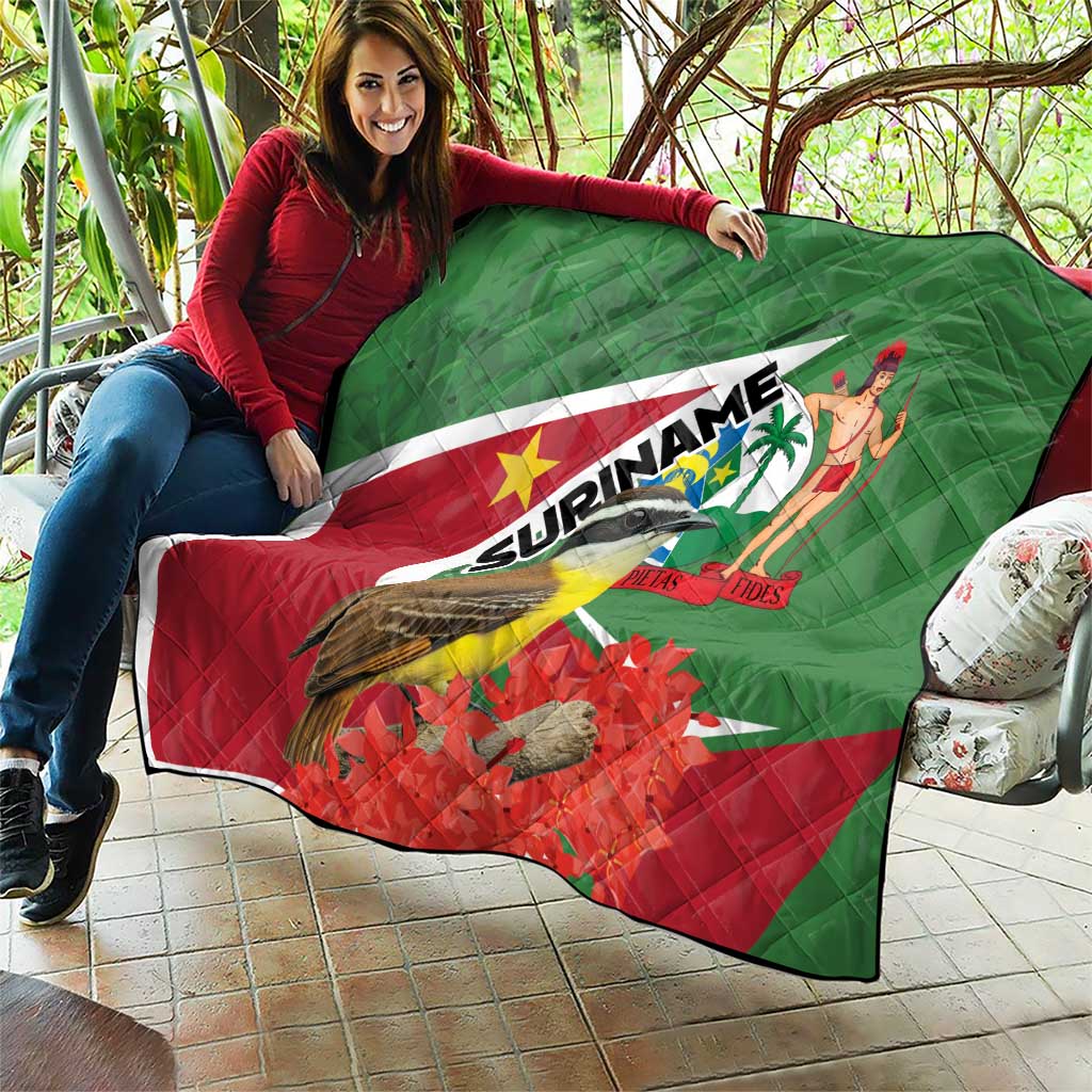 Suriname flag quilt draped on couch with bird and palm dancer, green red quilted weave