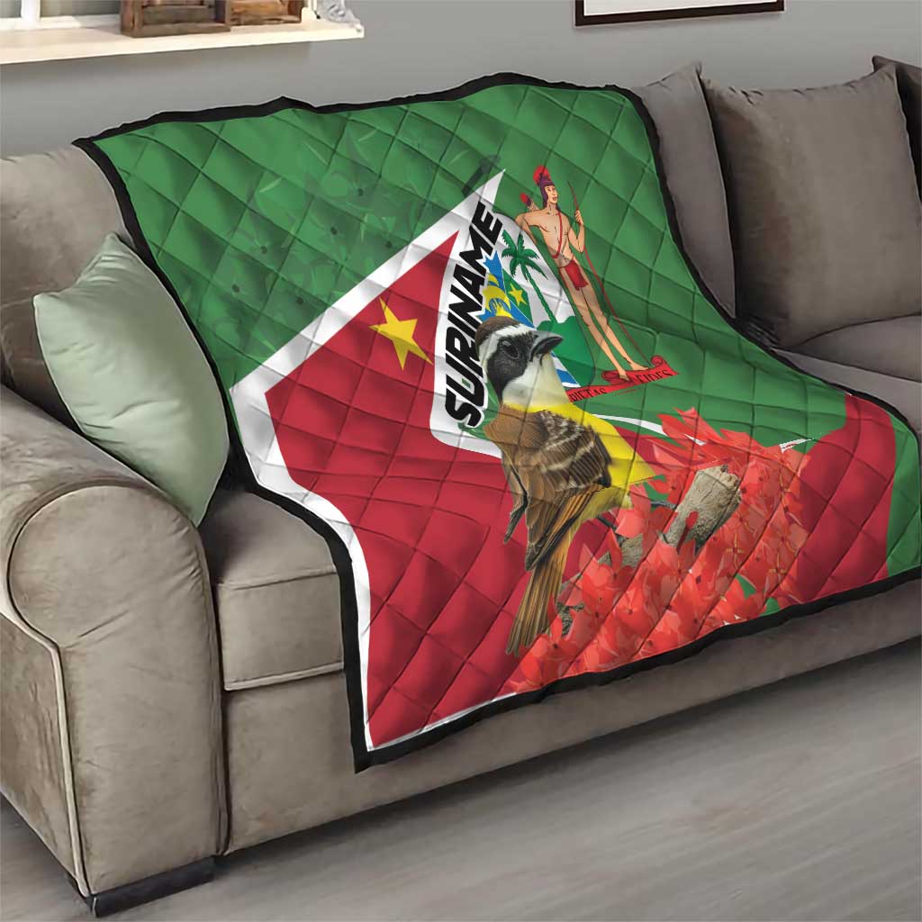 Suriname flag quilt on gray sofa with bird and SURINAME wordmark, red flower details