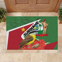 Green rubber doormat featuring Suriname logo, bird, dancer figure, red/white stripe